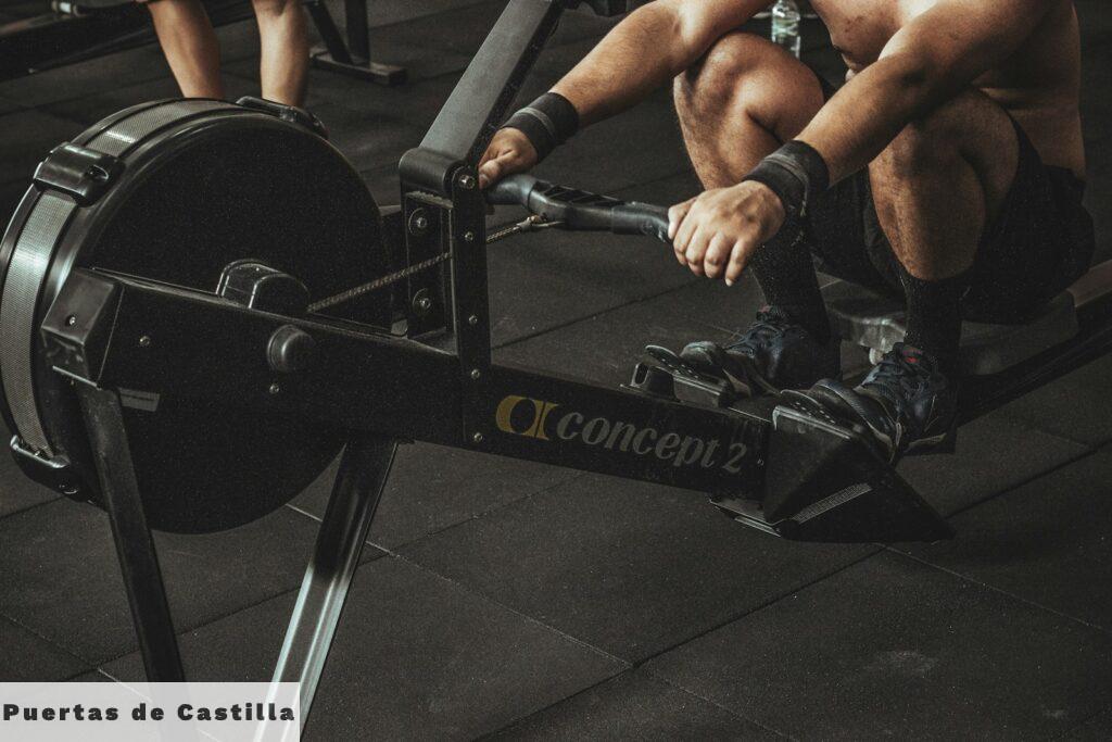 topless man using rowing machine