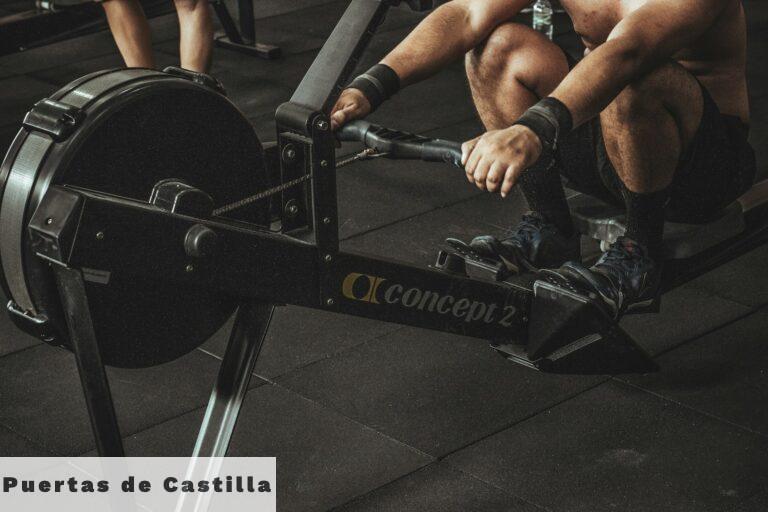 topless man using rowing machine